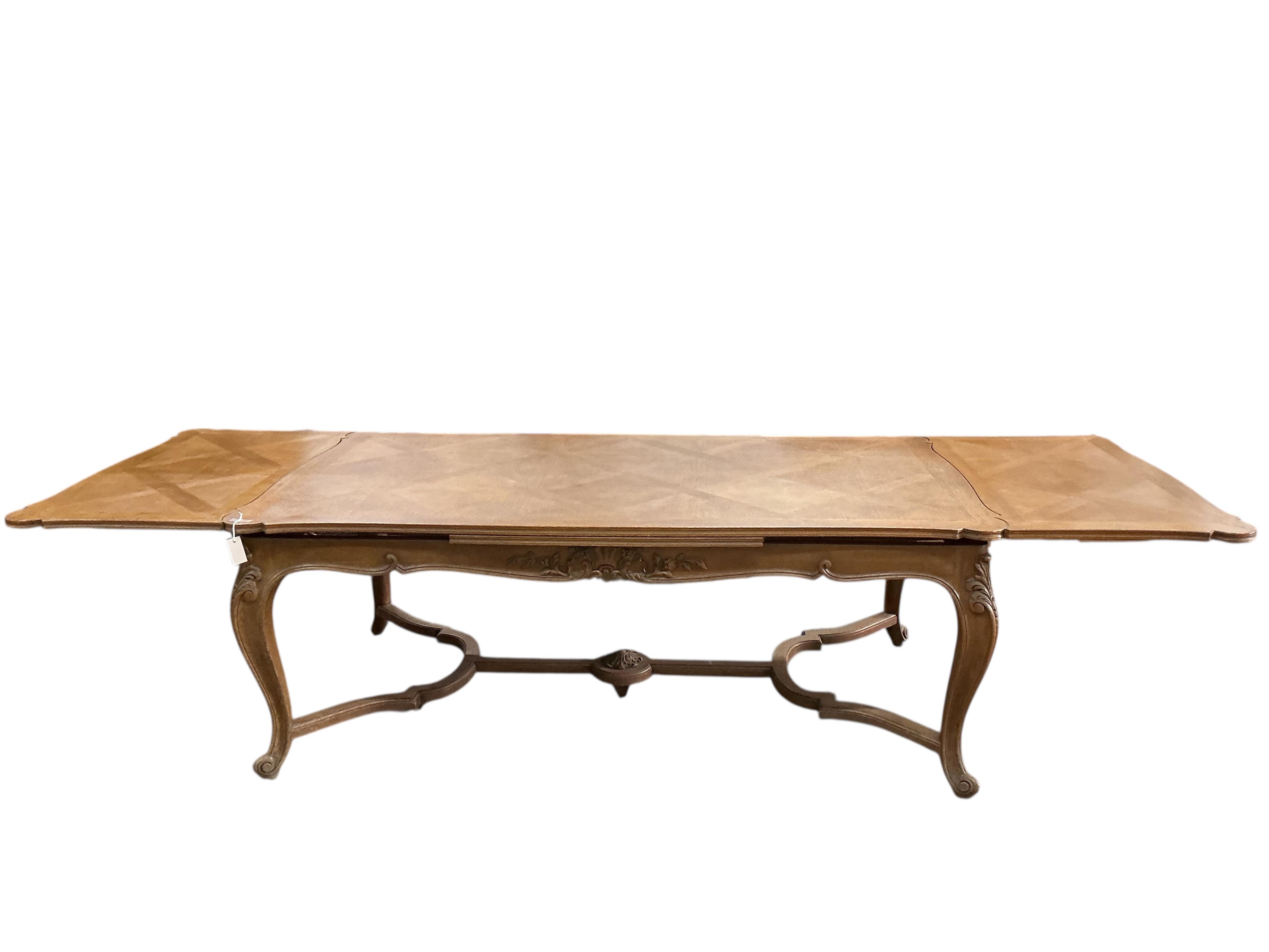 A French rectangular parquetry draw leaf dining table on acanthus carved cabriole legs, width 199cm, (320cm extended), depth 119cm, height 76cm